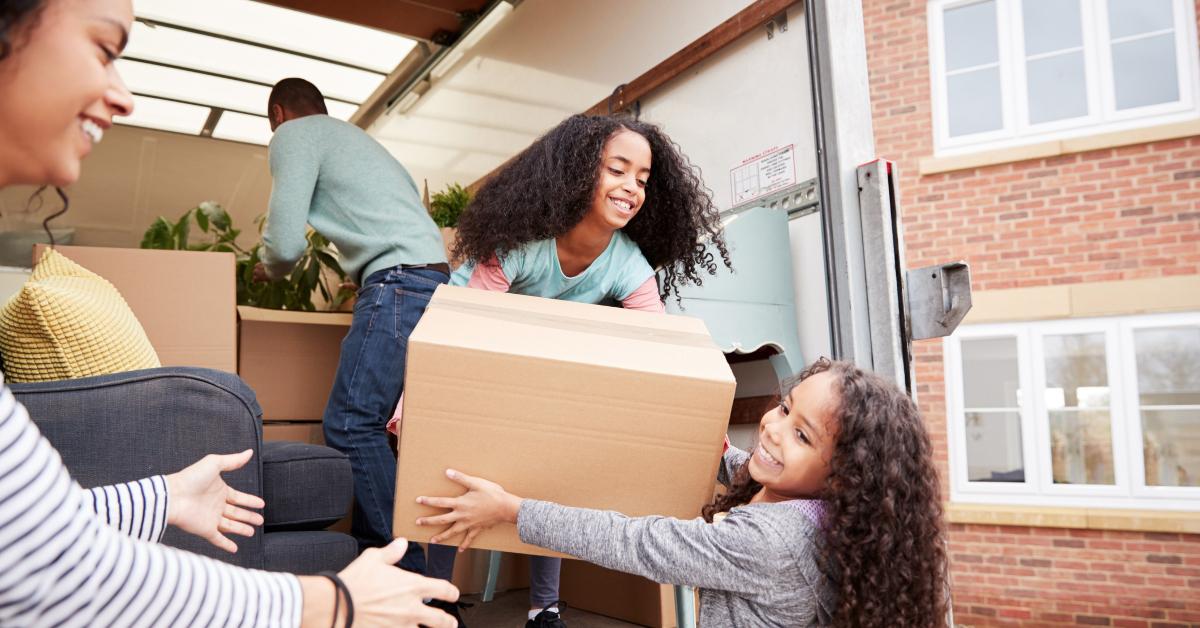 Family moving boxes from a moving truck