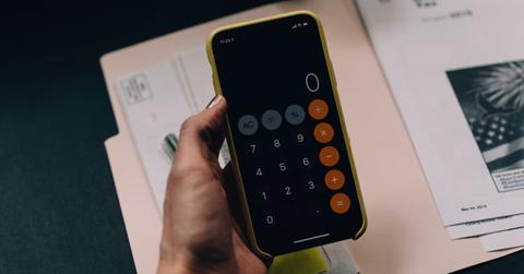 A person using a calculator to determine a tax refund