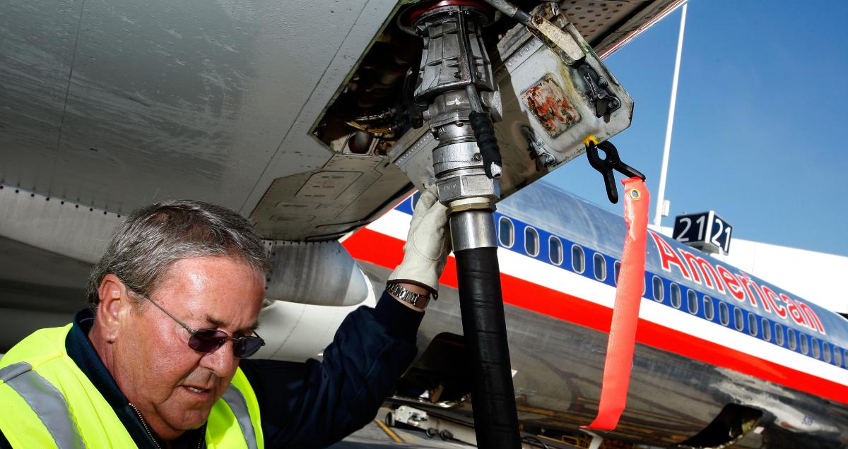 A worker putting jet fuel into an airplane