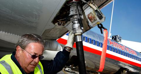 A worker putting jet fuel into an airplane