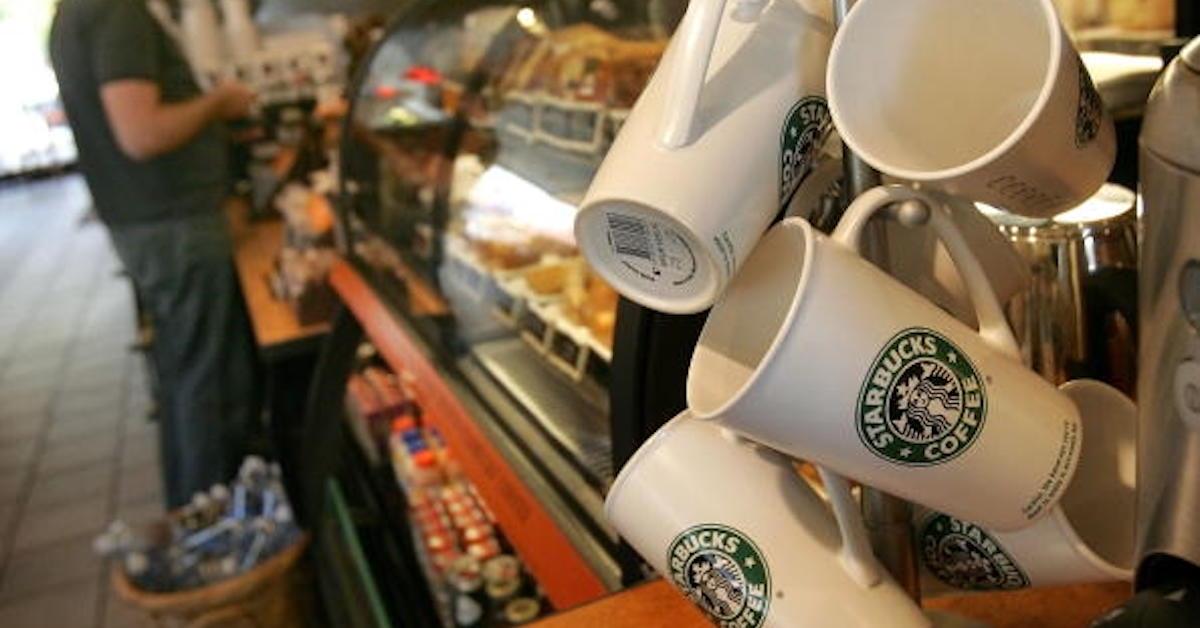 A display of Starbuck coffee mugs at eh counter of a Starbucks store.