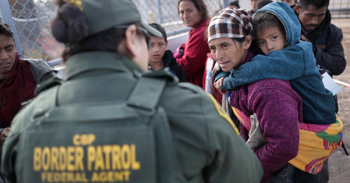 A border patrol agent talking to immigrants