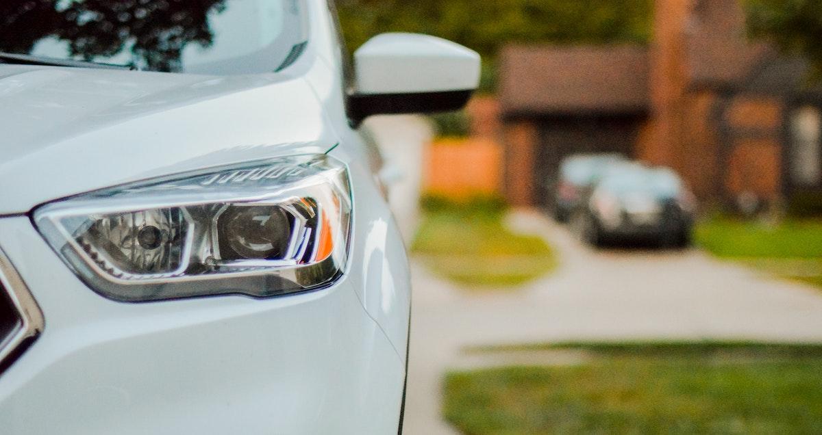 A car in the foreground with driveway in the background