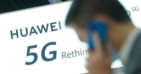 Huawei 5G advertisement with a man on a cellphone walking in front of it