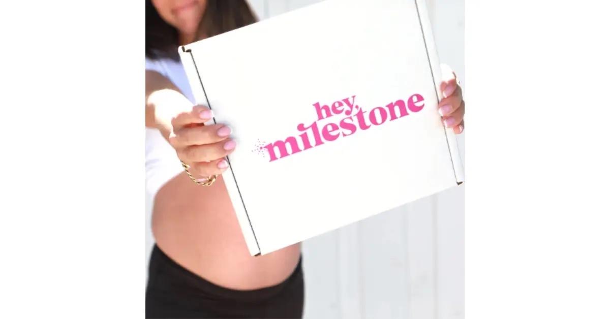 A white and pink Hey, Milestone gift box for expecting moms.