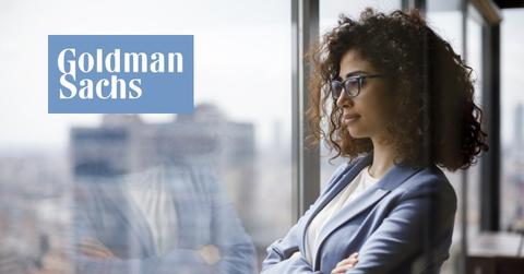 Woman looking out a window and Goldman Sachs logo