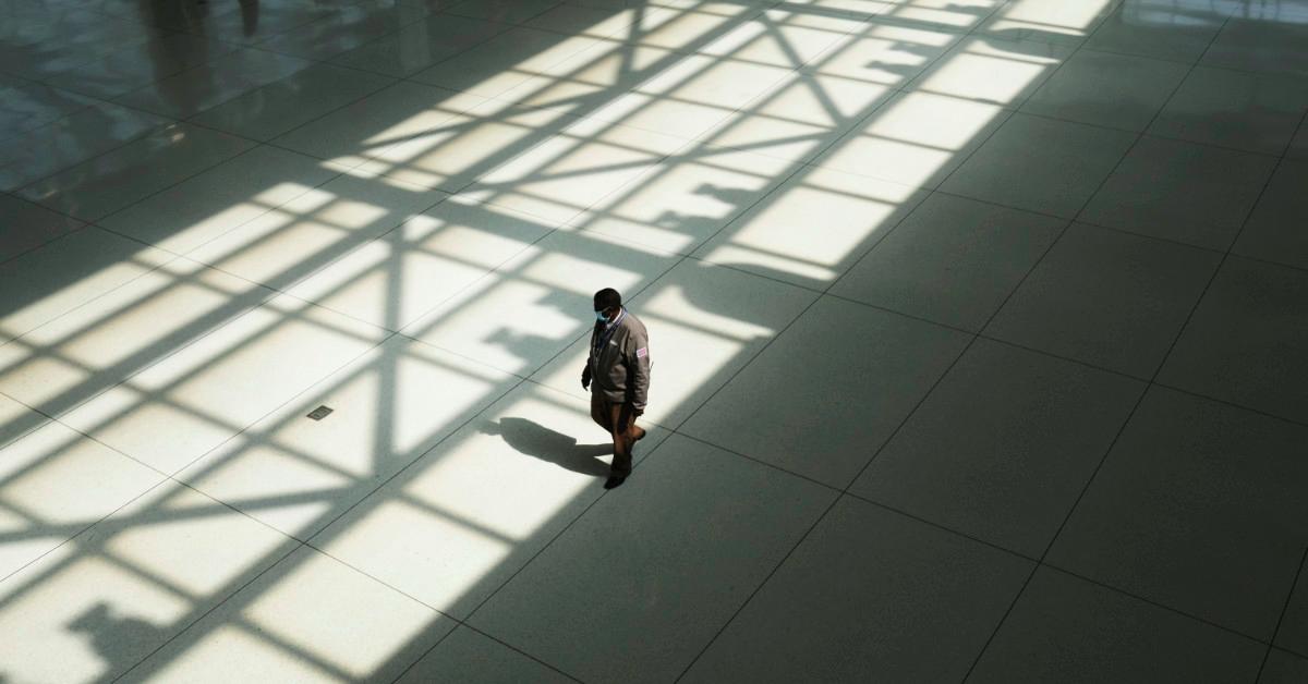 Worker walking through empty airport terminal