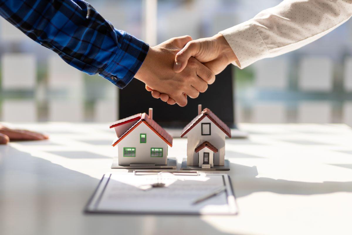 Real estate agents shake hands after signing a contract agreement