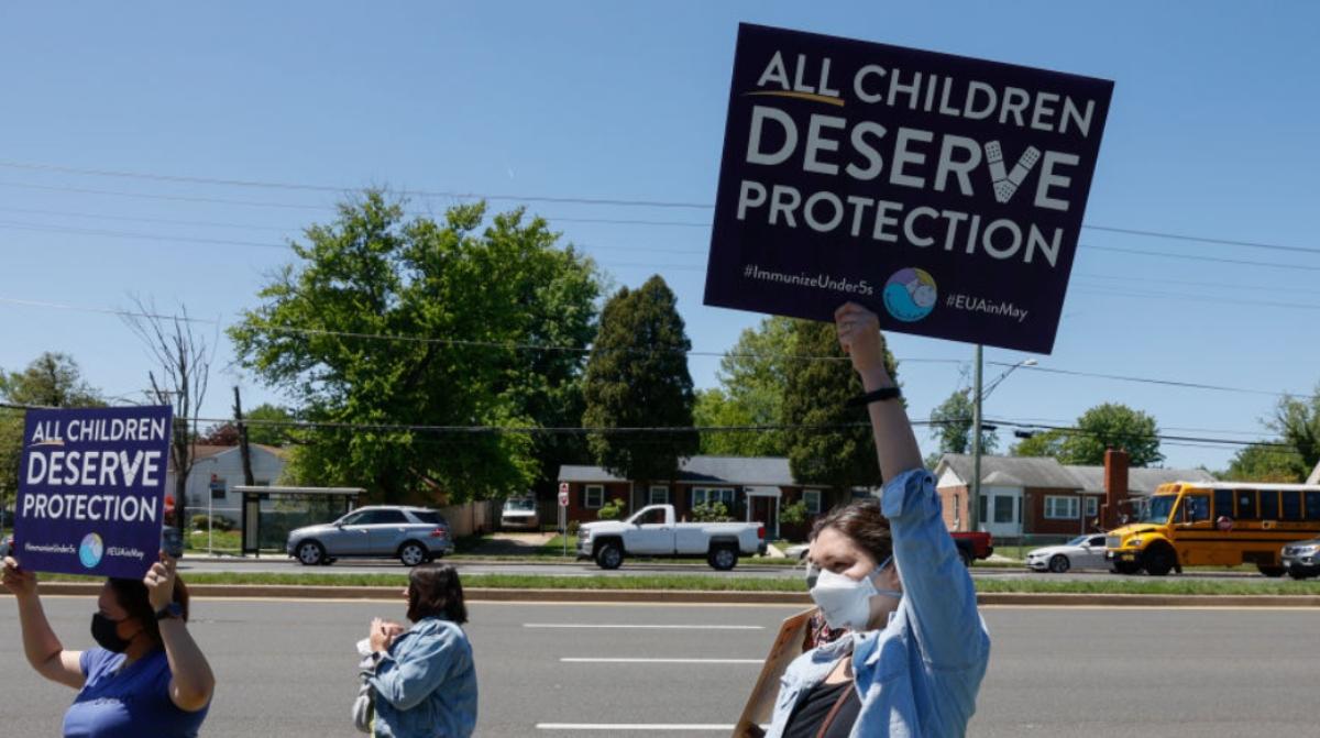 People holding demonstration signs for child vaccines