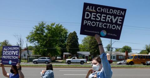 People holding demonstration signs for child vaccines