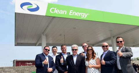 Clean Fuels executives posing in front of a fuel pump