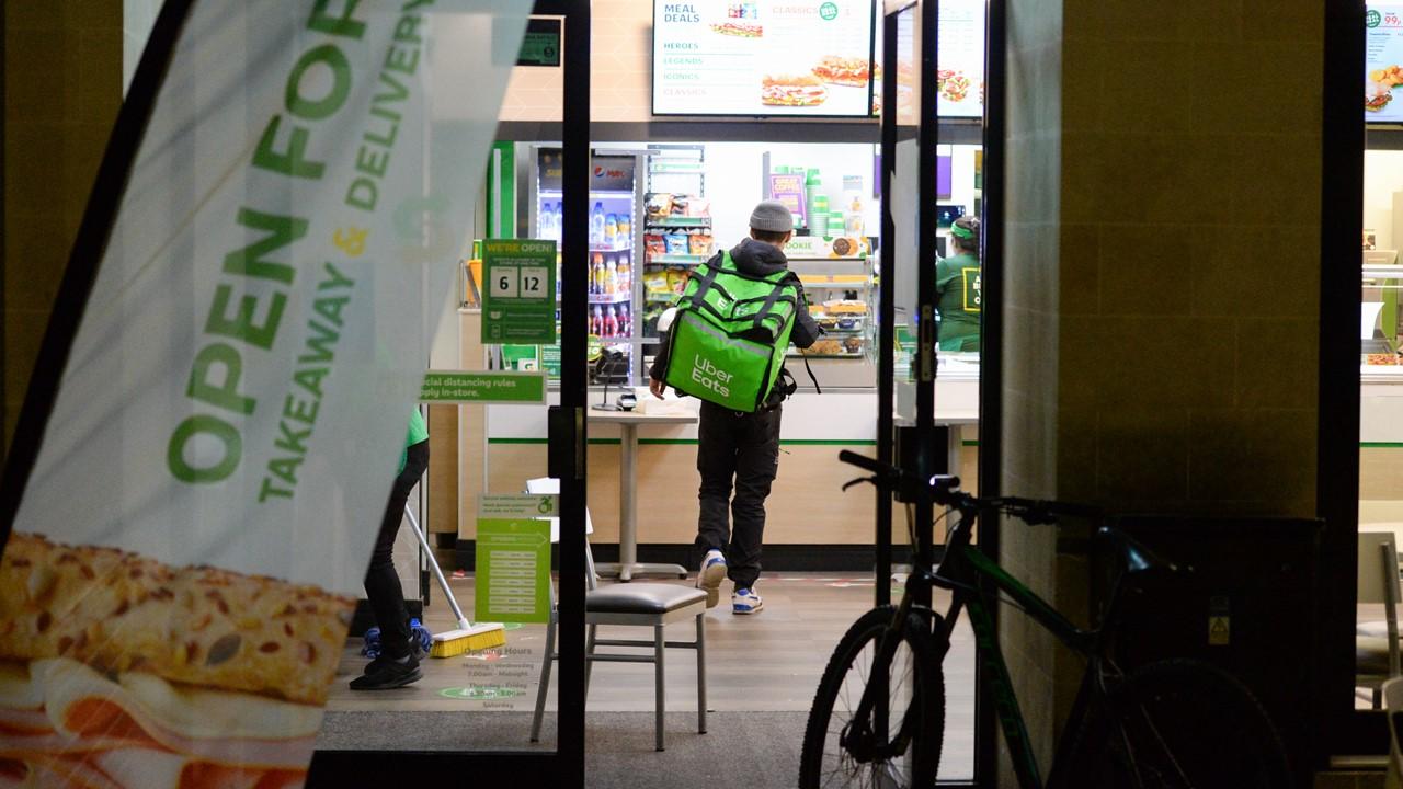 An Uber Eats delivery person picking up an order at Subway.