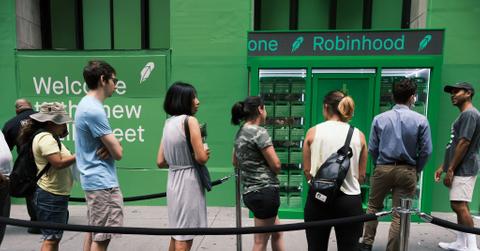 People waiting in line by a Robinhood sign