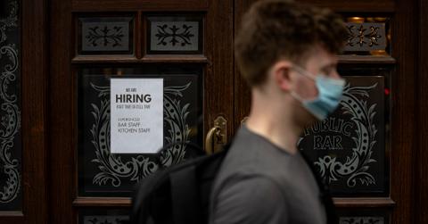 Perspn walks in front of a jon opening ad