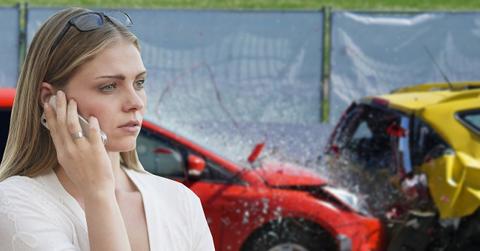 A woman on a call with a car crash in the background