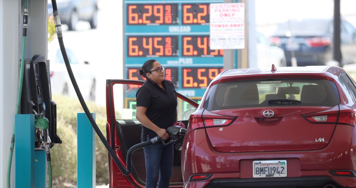 A woman putting gas in her car