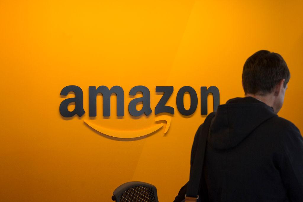  A man walking past an Amazon sign