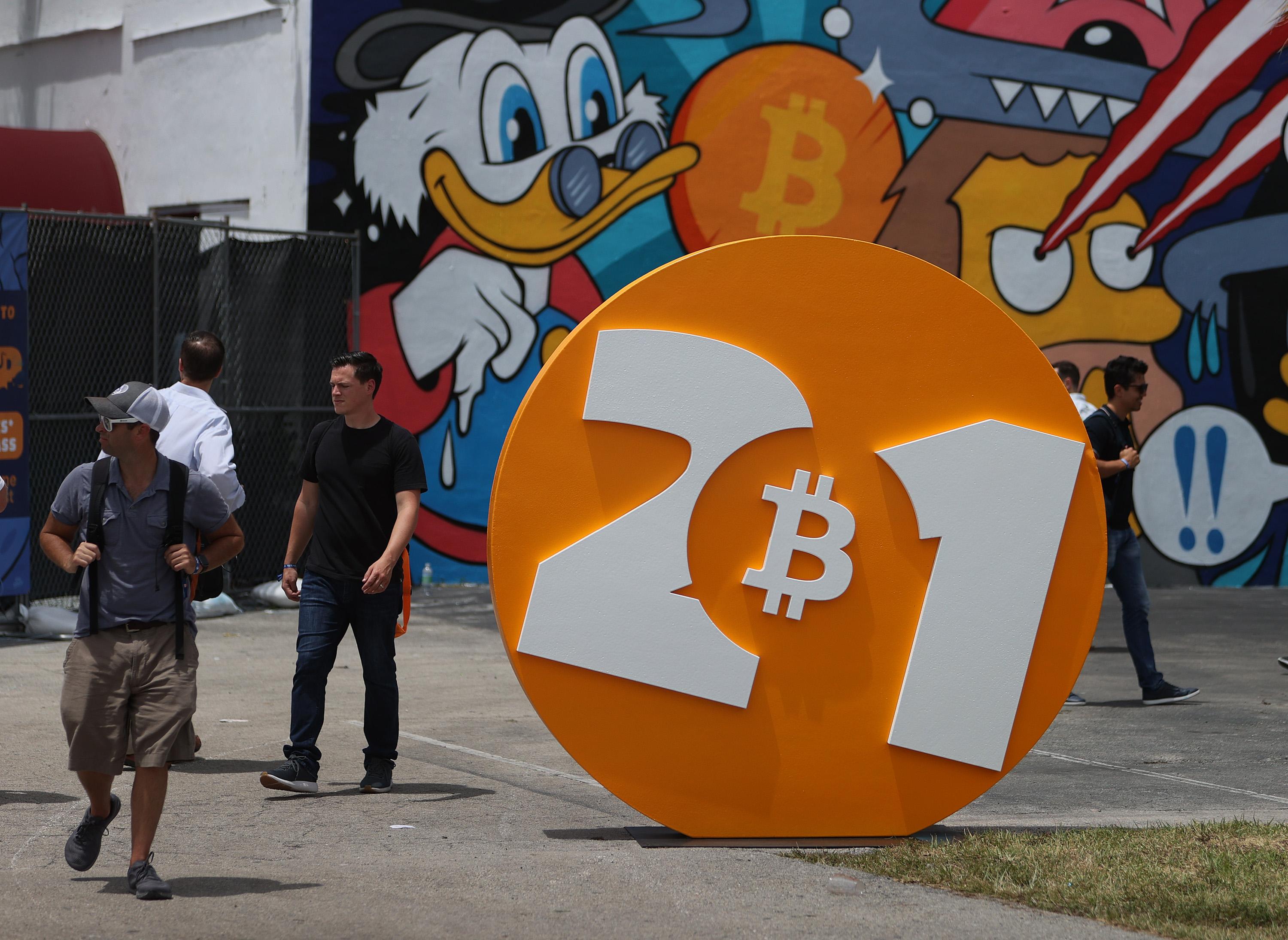 People walking around a large Bitcoin ad