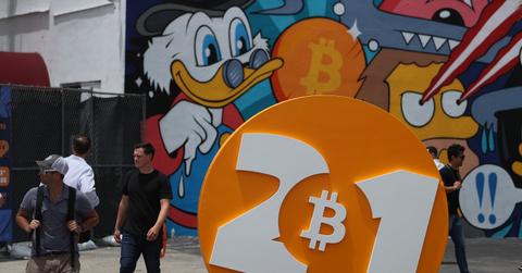 People walking around a large Bitcoin ad