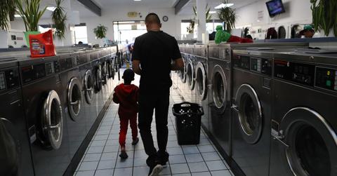 A man and boy walking in a laundromat