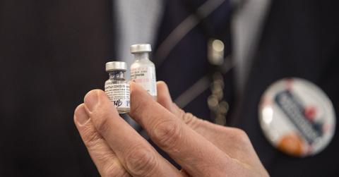 A man holding vials of the Pfizer COVID-19 vaccine