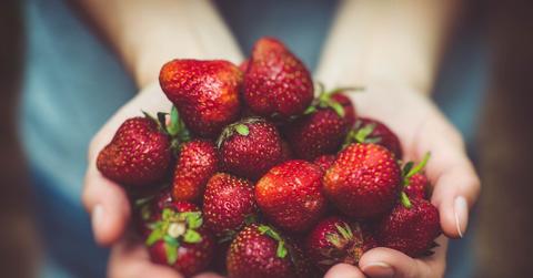 A person holding strawberries