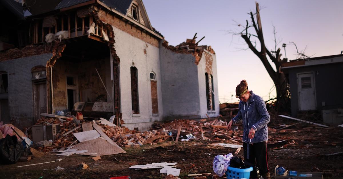 A woman cleaning up debris after a tornado in Kentucky