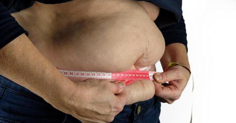 A person measuring their belly