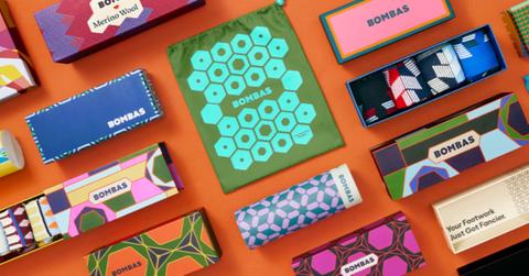 Colorful Bombas socks displayed with an orange background.