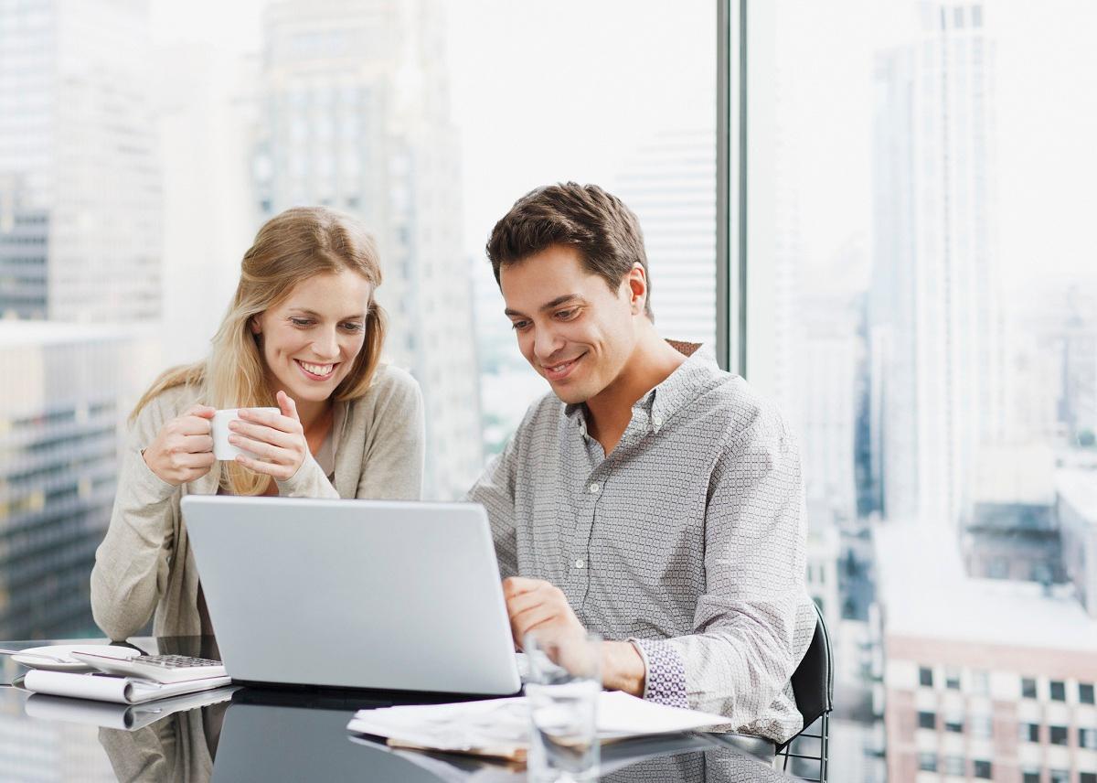 Business people using laptop together