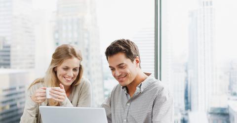 Business people using laptop together