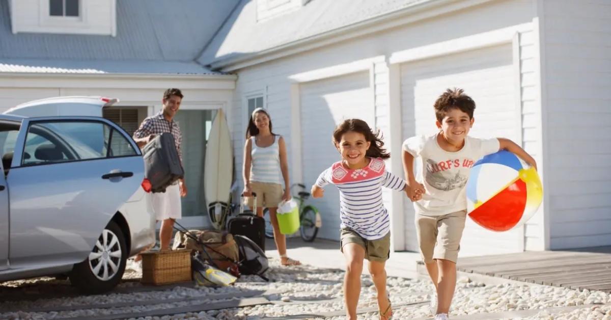 A couple and their two kids arrive at their white family beach house.