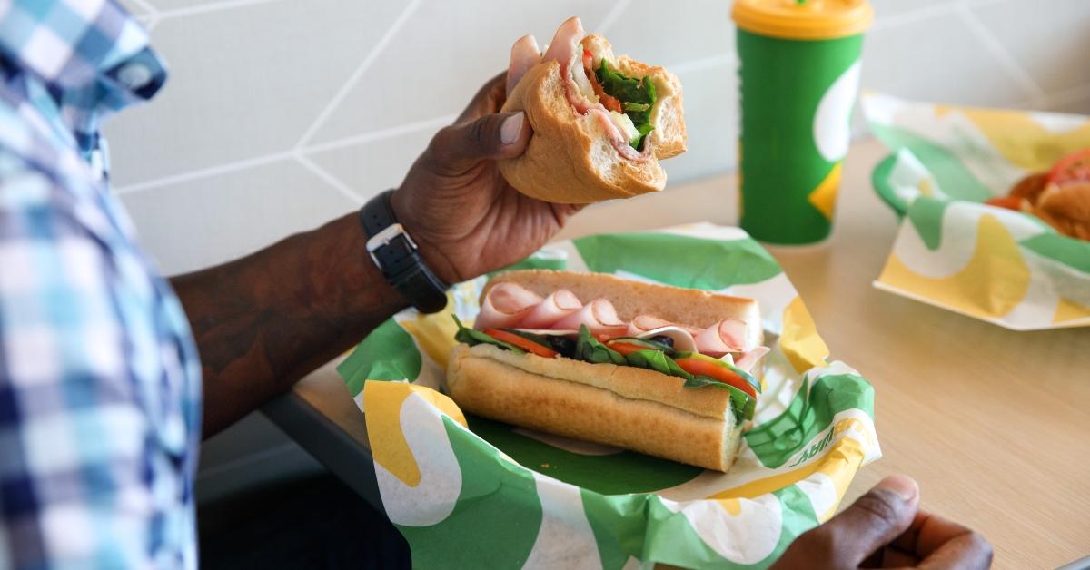 A man eating a Subway sandwich