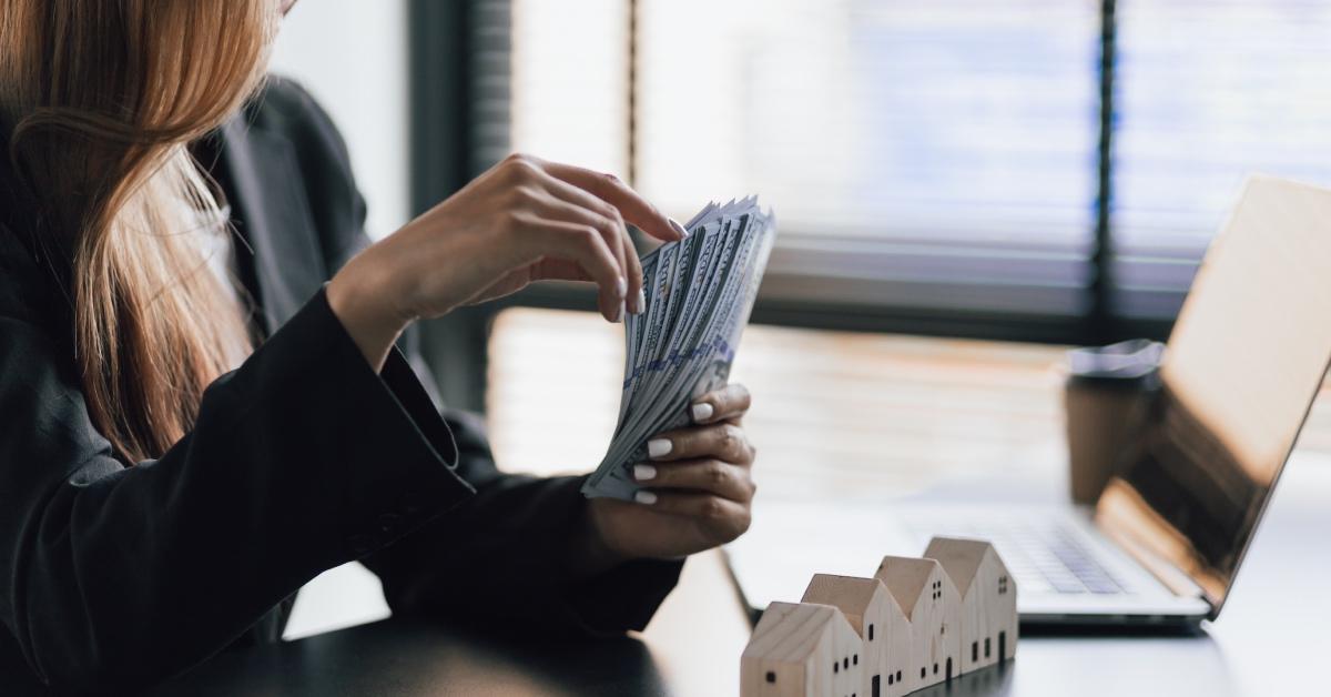 A businesswoman counts cash to use as a downpayment for a home.