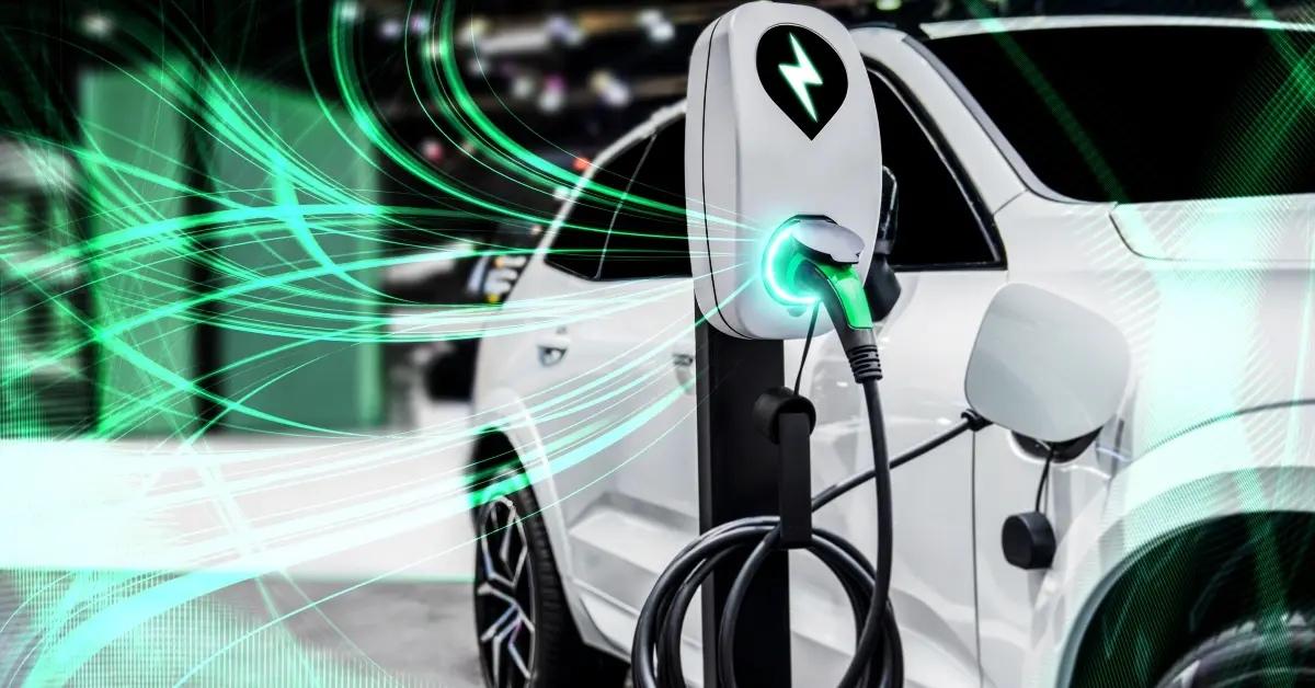 A white electric vehicle plugged into a charging station.