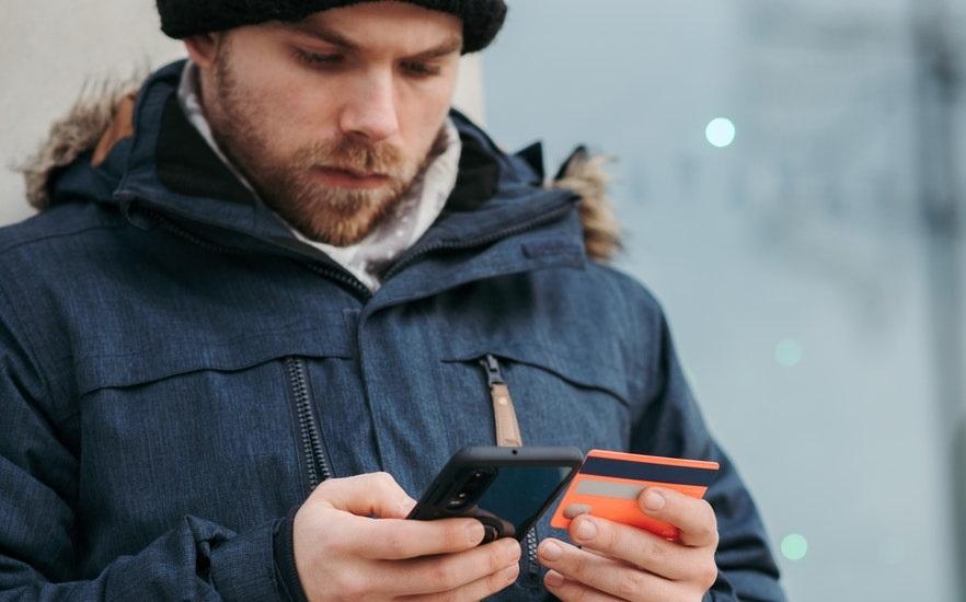 Pensive man holding credit card