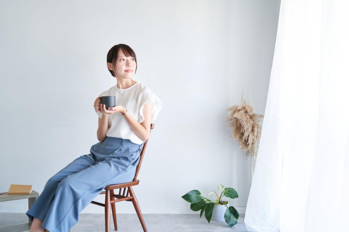 A woman sitting at the window enjoying a cup of coffee