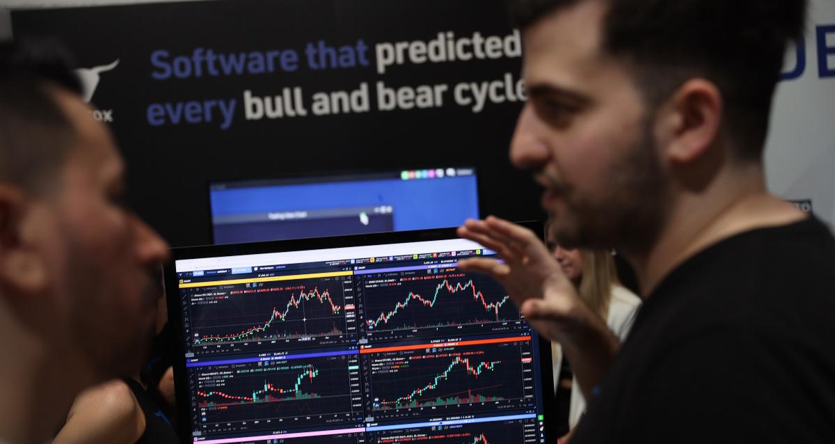 Traders look at crypto charts on screen