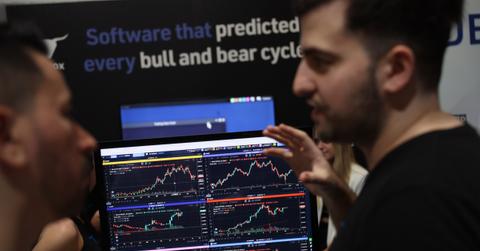 Traders look at crypto charts on screen