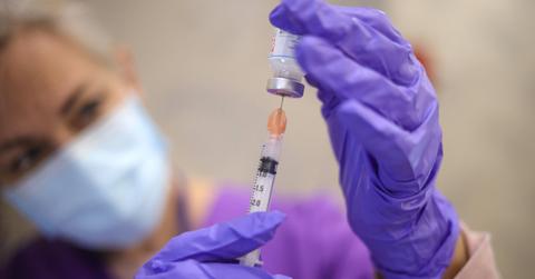 Nurse drawing up a COVID-19 vaccine