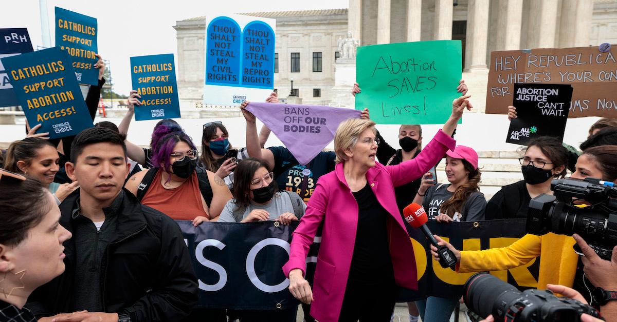 Sen. Elizabeth Warren (D-MA) stands with pro-choice activists protesting outside the Supreme Court after  a rumored draft opinion that would overturn Roe v. Wade was leaked to POLITICO.