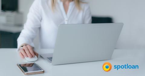 A woman using a laptop and the Spotloan logo