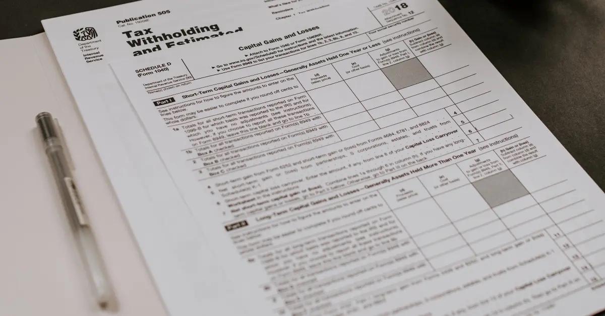 Income tax forms sitting in a folder on a desk.