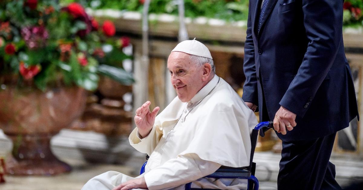 Pope Francis being pushed in a wheelchair