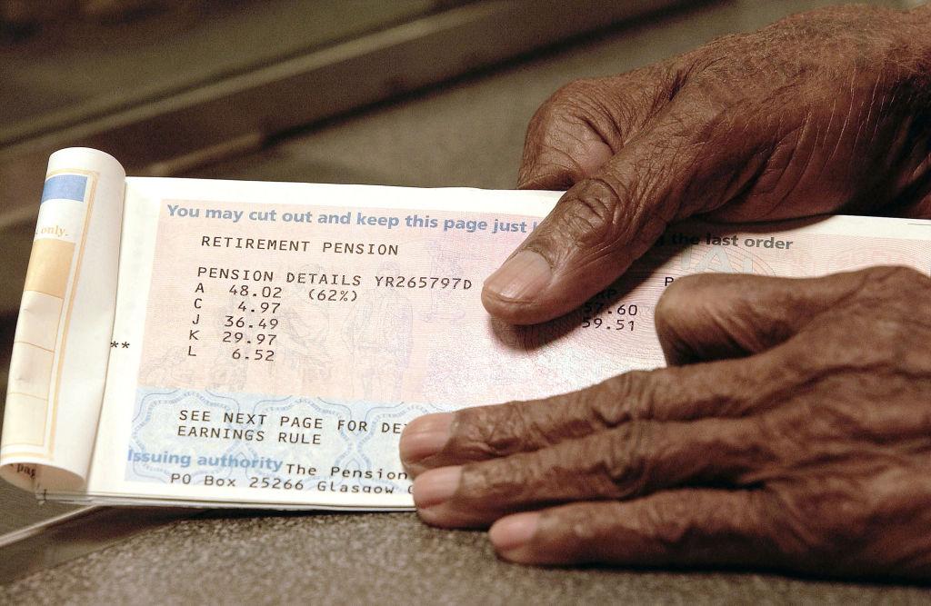 An elderly man holding his pension funds.