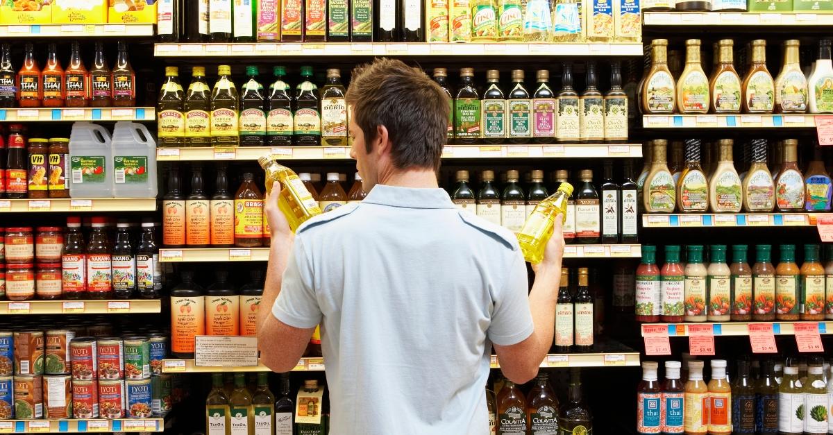 Man looking at oil in grocery store