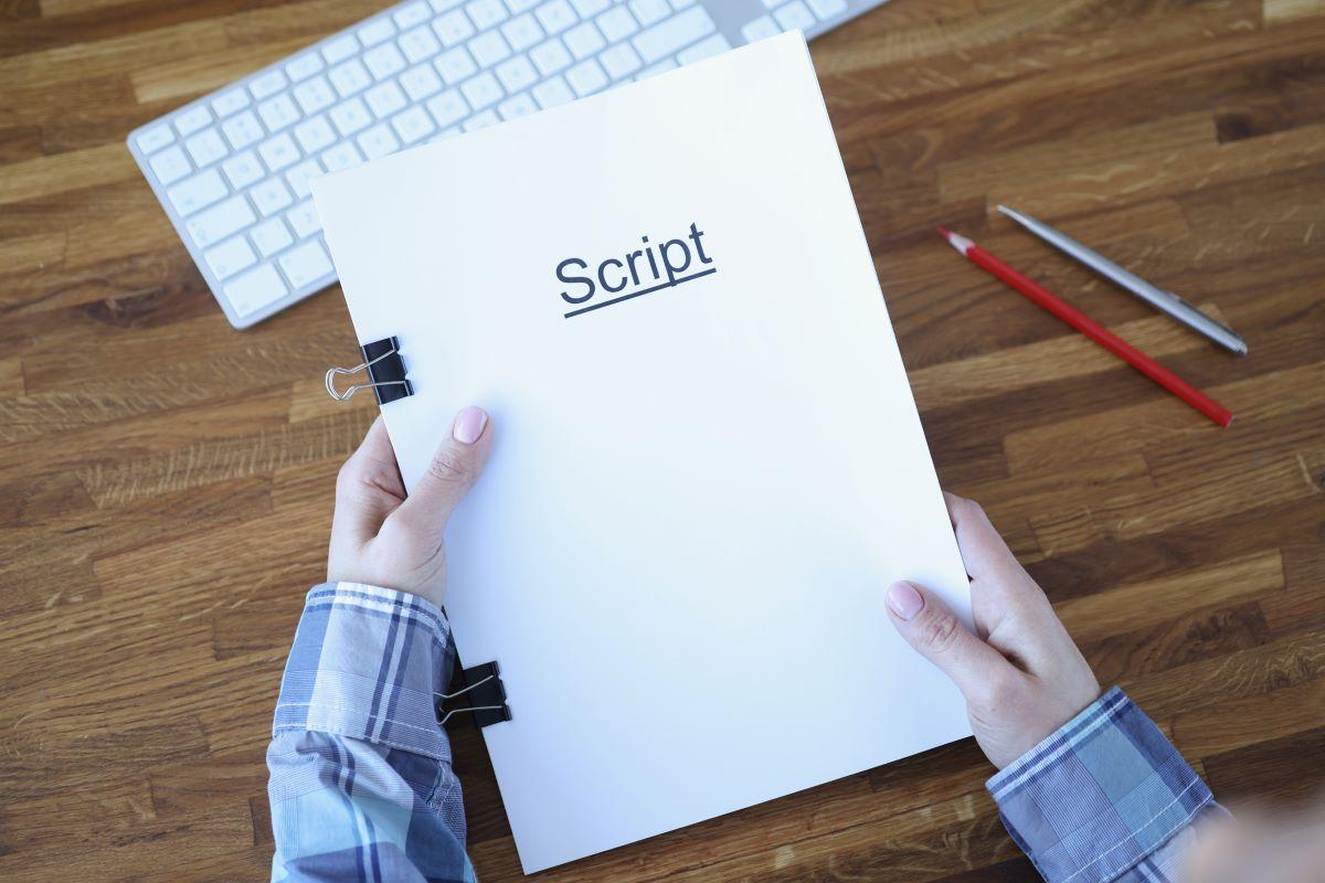 Screenwriter holds a folder of documents labeled "Script"